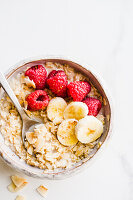 Oatmeal Bowl with raspberries, bananas and coconut flakes