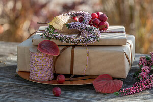 Two gifts decorated with flower hearts of heather and ornamental apple on garden table