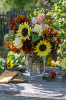 Bouquet with sunflowers (Helianthus), roses (Rosa), broccoli, wild carrot, foxtail (Amaranthus) on garden table