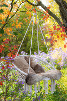 Hanging chair in autumn garden