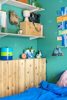 Open shelves, including narrow wooden wardrobe in bedroom with blue walls