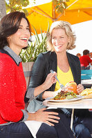 Zwei Freundinnen beim Essen im Freien