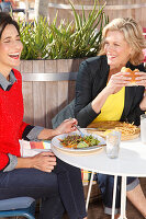 Zwei Freundinnen beim Essen im Freien