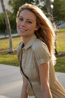 Blonde woman in light summery blouse dress outside