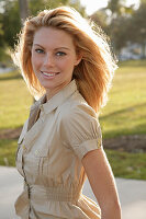 Blonde woman in light blouse dress outside