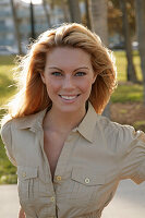 Blonde woman in light blouse dress outside