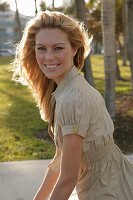 Blonde woman in light blouse dress outside