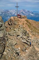 Hikers relaxing at the foot of the summit of the parpaner rothorn, alpine resort of lenzerheide, swiss alps, canton of the grisons, switzerland