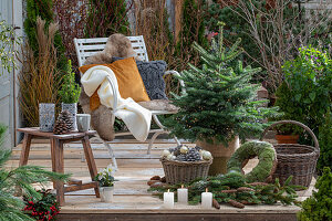 Terrasse mit Weihnachtsschmuck, Nordmanntanne mit Lichterkette, Tannenzweige, Kerzen, und Sitzplatz