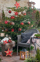 Geschmückter Christbaum neben Sitzplatz auf der Terrasse