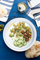 Lamb meatballs with Greek yogurt sauce, olive salad, cucumber, and olive oil