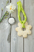 Flower-shaped Easter cookie with pearl sugar on green decorative ribbon