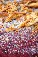 Puff pastry crumbs and confectioner's sugar on a red background