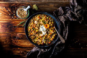 Grandma's lentil stew with bacon, root vegetables and sausages