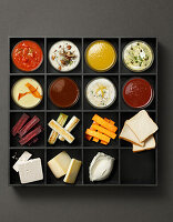 Tray with various sauces, vegetable sticks and cheese