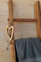 Towel on rustic wooden ladder with heart pendant