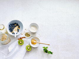 Ingredients for muesli - oat flakes, kiwi, almonds, honey