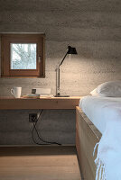 Minimalistisches Schlafzimmer mit Betonwand und integriertem Schreibtisch
