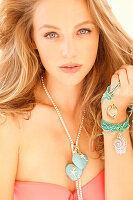 Blonde young woman in salmon-coloured bikini with turquoise-silver jewellery