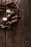 Easter wreath with pussy willows and eggs on a wooden base