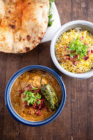 Pork curry with pulao rice and naan bread (India)