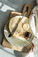 Plate with bread and jars of lemon and chocolate honey