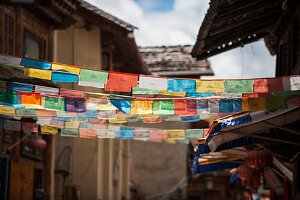 Gebetsfahnen in einer alten Stadtgasse; Zhongdian, Yunnan, China