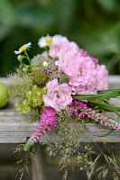 Summer bouquet with roses (pink) and grasses on a wooden table