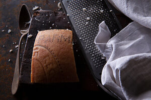 Still life with Parmigiano Reggiano rind, cheese grater and vintage spoon