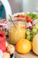 Fruity dressing in a jar with fresh grapes and orange