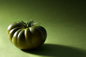 Grüne Marmonde-Tomate auf grünem Hintergrund