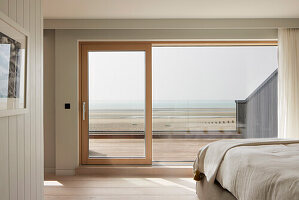Bedroom with view of the beach through large sliding window door