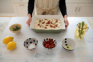 Unbaked focaccia with sun-dried tomatoes and herbs