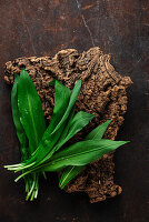 Wild garlic leaves on a rustic wooden base