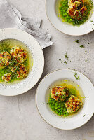Vegetable broth with cheese dumplings and peas