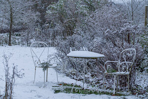 Snow in the garden with snow-covered seating area