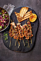 Grilled lamb souvlaki skewers with red cabbage salad and toasted bread