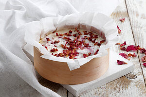 Cheesecake with raspberries sprinkled with rose petals