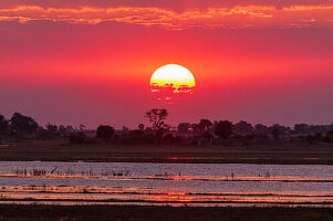 Ein farbenprächtiger Sonnenuntergang am Ufer des Chobe-Flusses, Chobe-Nationalpark, Kasane, Botsuana.