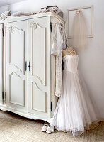 White wardrobe, wedding dress on a dressmaker's dummy and vintage decor in the bedroom