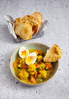 Vegetarisches Blumenkohlcurry mit Eiern und Naan-Brot