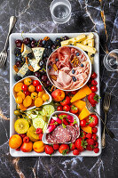 Antipasti-Platte mit Käse, Aufschnitt und Früchten
