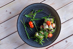 Cucumber rolls with smoked salmon, olives and tomatoes