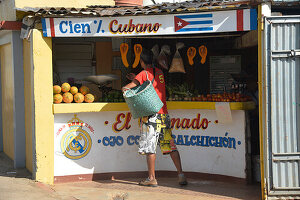 Kuba,Baracoa,ein Mann trägt einen Korb und kauft in einem Laden ein, der lokales Obst und Gemüse verkauft