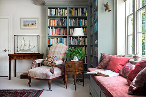 Klassisches Lesezimmer mit Büchersammlung und gemütlicher Fenstersitzbank