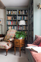 Gemütliche Leseecke mit Bücherregal und kariertem Sessel im Wohnzimmer