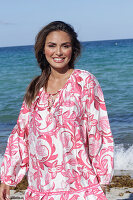 Woman in floral tunic on the beach