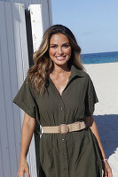 Woman in khaki coloured dress on the beach