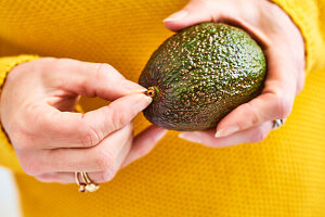 Ripe avocado in the hand