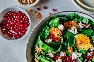 Spinach and orange salad with cheese, walnuts and pomegranate seeds